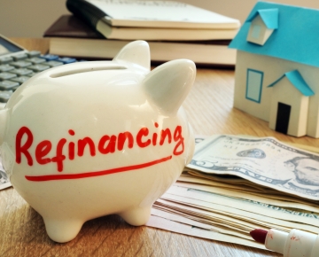 Refinancing written on piggy bank with cash in background