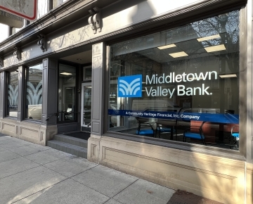 office building with signs in window next to sidewalk