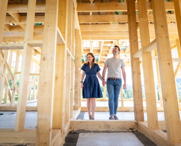 couple walking through house under construction
