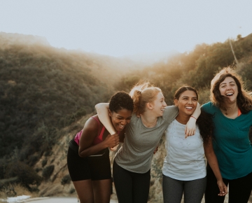 four women hiking and laughing together
