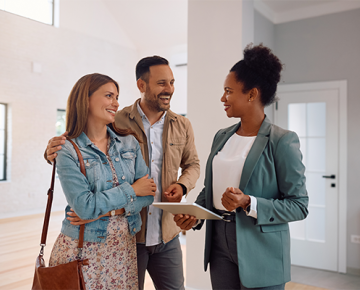 Couple talking to real estate agent in home