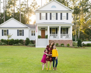 mom in front of house with two kids